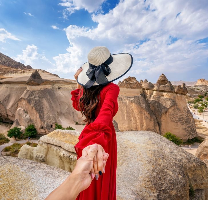 women-tourists-holding-man-s-hand-leading-him-fairy-chimneys-cappadocia-turkey (1)